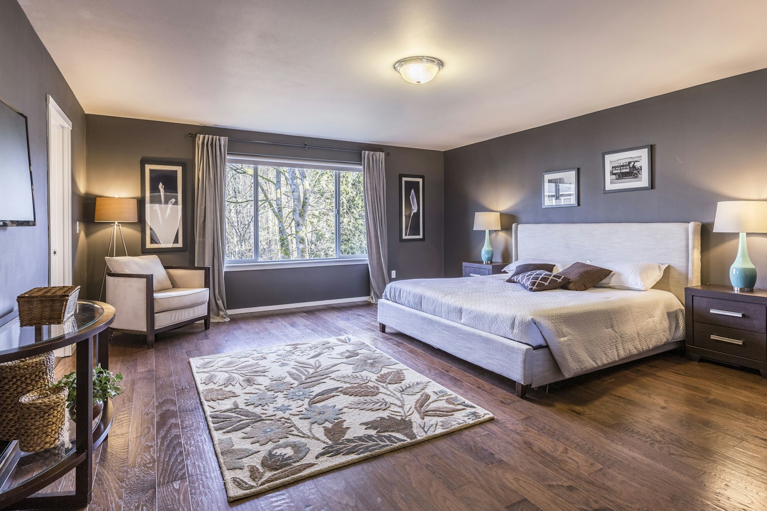 A furnished bedroom with a comfortable bed and large window